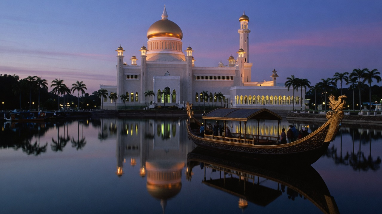 The golden dome of the Omar Ali Saifuddien Mosque reflected in its lagoon at dusk in Bandar Seri Begawan